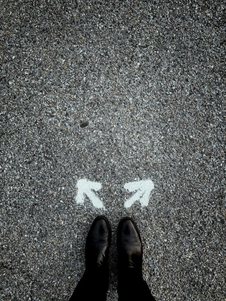 Feet standing on asphalt with directional arrows.